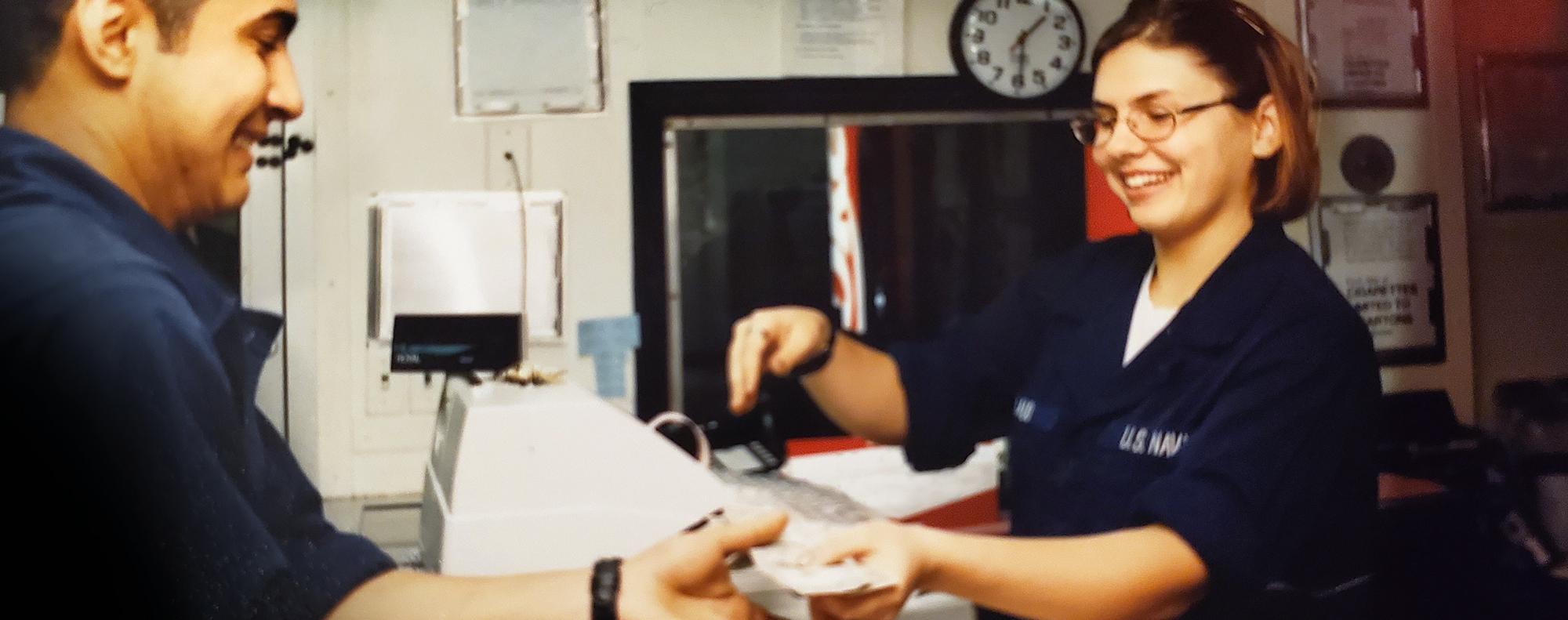 Melissa as a young Navy officer handing change to a shipmate in the on-board store