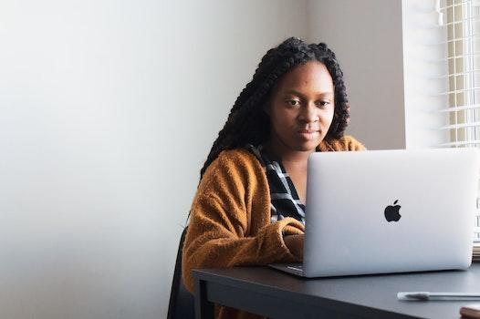 A young woman searches for teaching program financial aid options on her laptop